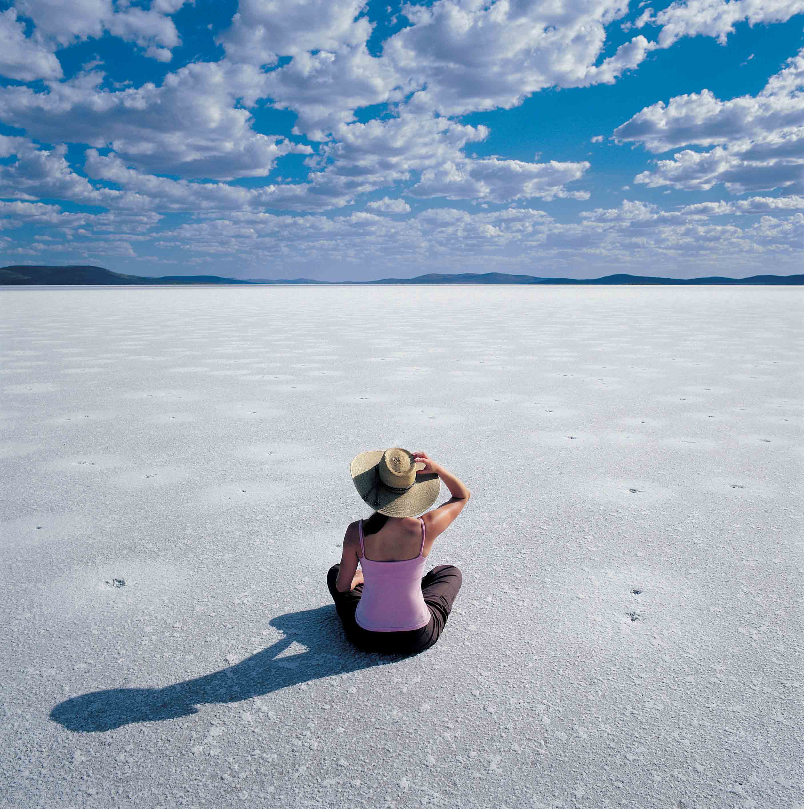 Frau mit Hut sitzend am Lake Gairdner Salzsee, Südaustralien